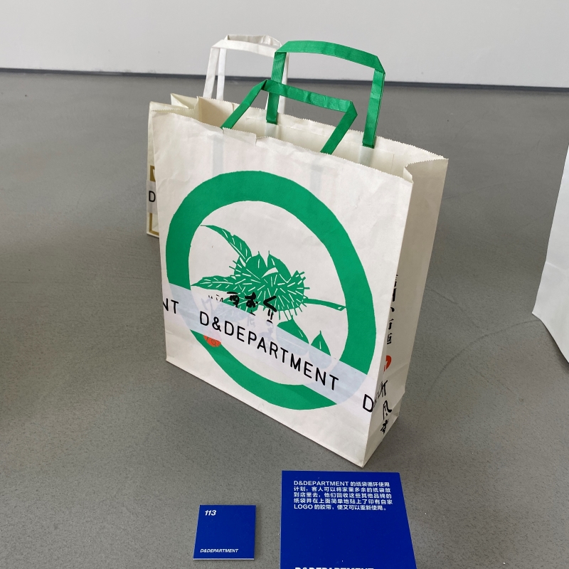 D&DEPARTMENT纸袋循环使用计划，在消费者带来的其他纸袋表面贴上自己的LOGO胶带，就可以重新使用了